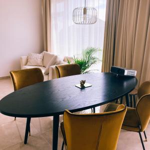 una mesa negra y sillas en la sala de estar. en Atostogų namai Palangoje Saulė, en Palanga