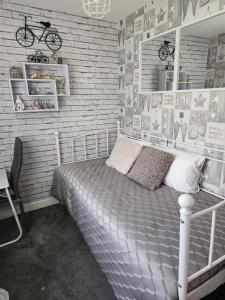 a bedroom with a bed and a brick wall at Rehoboth in Yew Gardens in Doncaster
