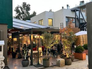 a patio with people sitting at tables and plants at Apart Hotel Castellon 176 in Concepción