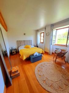 um quarto com uma cama com um cobertor amarelo e um tapete em La Maison d'Ipso em Les Pins