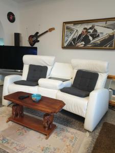 a living room with a white couch and a table at Design Apartments Tomelana in Ličko Petrovo Selo