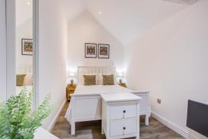 a white bedroom with a bed and a mirror at Beautiful One Bedroom Apartment in Brentwood