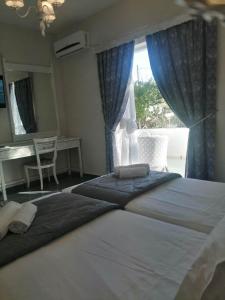 a bedroom with two large beds and a window at Manolis&Xenia in Kefalos