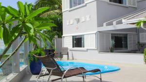 - une piscine avec 2 chaises et une maison dans l'établissement Casa frente mar - Penha/SC, à Penha