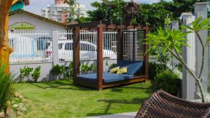 a gazebo with a blue couch in a yard at Casa frente mar - Penha/SC in Penha