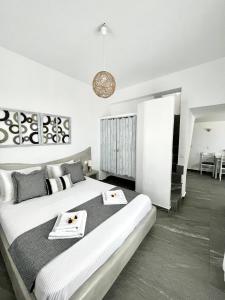 a white bedroom with a large bed with two plates on it at Alonistra Oia Houses in Oia