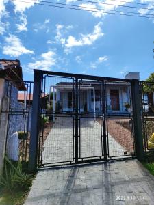 a gate in front of a house at Quarto, piscina e acesso exclusivo in Encantado