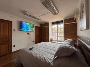 1 dormitorio con 1 cama y TV en la pared en Casona Lorena, en Santiago