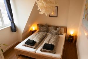 two beds in a small room with two lamps at Wölkchen - Wohnung mit Balkon, Holzdielen & TV in Bremerhaven