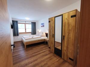een kleine kamer met een bed en een spiegel bij Appartement Lackner in Filzmoos