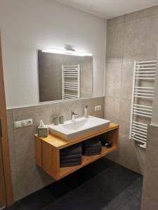 een badkamer met een wastafel en een spiegel bij Appartement Lackner in Filzmoos