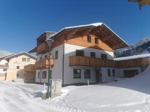 een groot gebouw met sneeuw op de grond bij Appartement Lackner in Filzmoos