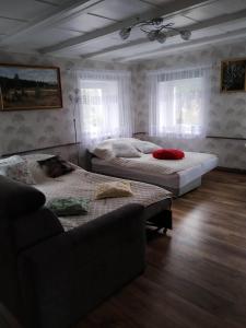 una camera con due letti e un divano in camera di "Agroturystyka pod Magnolią" Rybnica 33 a Rybnica