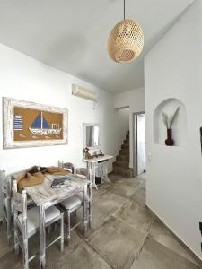 una sala da pranzo con tavolo, sedie e scala di Alonistra Oia Houses a Oia