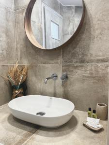 un bagno con un lavandino bianco e uno specchio di Alonistra Oia Houses a Oia Altre 57 foto