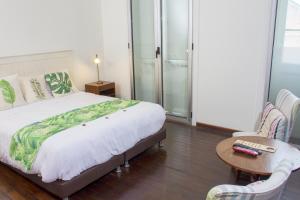 a bedroom with a large bed and a table and chairs at Hotel Casa de la Vega in Bogotá