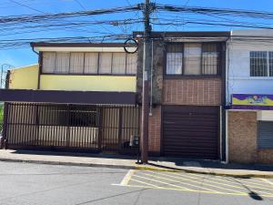ein Gebäude mit Garagentor auf einer Straße in der Unterkunft El Parque Bed and Breakfast in Alajuela