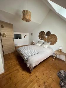 a bedroom with a large bed with a wooden floor at Le Refuge des Etoiles Gîte et Spa in Zutkerque
