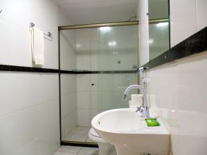 a bathroom with a shower and a toilet and a sink at FAROL BEACH Suítes in Salvador +33 photos