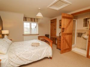 a bedroom with a bed and a bathroom at Cefn Cottage in Llangurig
