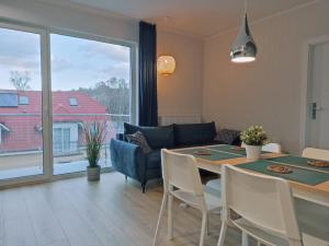 ein Esszimmer mit einem Tisch und einem großen Fenster in der Unterkunft Apartament Alicja in Międzywodzie