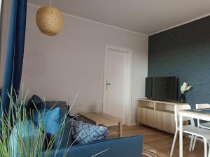 ein Wohnzimmer mit Tisch und Fernseher in der Unterkunft Apartament Alicja in Międzywodzie