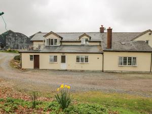 an old house with a gravel driveway at Cefn Cottage in Llangurig