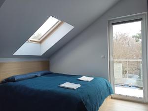 ein Schlafzimmer mit einem blauen Bett und einem Fenster in der Unterkunft Apartament Alicja in Międzywodzie + 16 Fotos