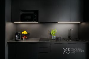 a kitchen with black cabinets and a counter top at Saint Martin Residence Old Town with Wellness in Poznań