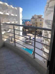 a balcony with a view of a pool and buildings at Elegant sea view apartment in Hurghada