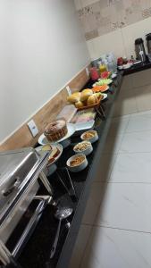 uma linha de buffet com muitos pratos de comida em Pousada Chapada do Araripe em Araripina