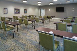 a conference room with tables and chairs and a screen at TownePlace Suites by Marriott Raleigh Durham Airport Morrisville in Morrisville