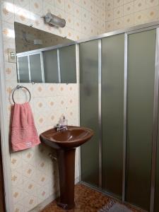 a bathroom with a sink and a shower at Quarto COMPÔ 6 in São João del Rei