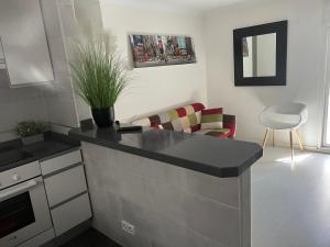 a kitchen with a counter top and a living room at Luminoso apartamento con precioso y amplio patio in Carabanchel Alto