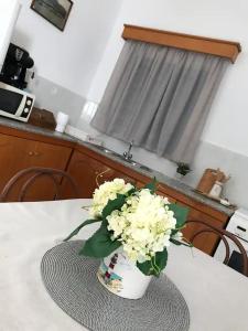 un jarrón blanco con flores blancas en una mesa en Villa Konstantina en Kalymnos