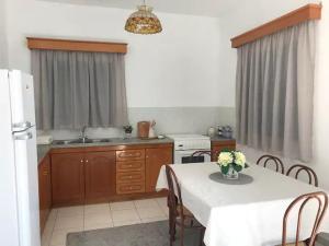 een keuken met een tafel met een witte tafeldoek erop bij Villa Konstantina in Kalymnos