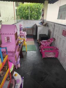 une pièce avec des jeux roses et une cuisine dans l'établissement Pousada Porto Aventura -Chalés da Luci, à Peruíbe 12 autres photos