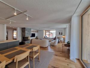 a dining room and living room with a table and chairs at Riverside 2nd Floor North in Saas-Fee