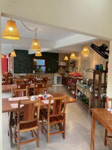 a restaurant with wooden tables and chairs and lights at Pousada Canto do Dado Praia de Itamambuca in Ubatuba