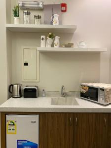 eine Küche mit einer Spüle und einer Mikrowelle in der Unterkunft New Day Resort منتجع يوم جديد in Ta'if