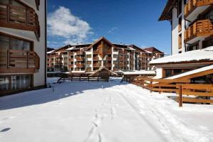 a resort in the snow with snow covered buildings at Bansko Private VIP Apartment in Bansko