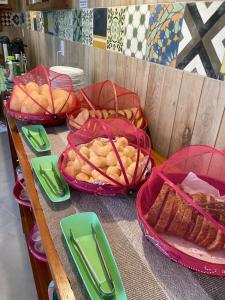 a table with three baskets of bread and pies at Pousada Canto do Dado Praia de Itamambuca in Ubatuba