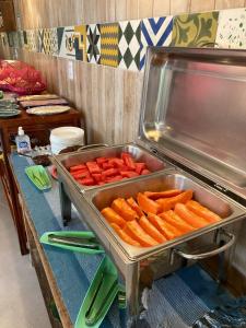 a buffet with a tray of carrots on a table at Pousada Canto do Dado Praia de Itamambuca in Ubatuba