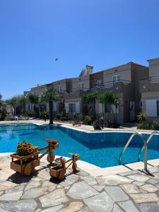 a swimming pool with tables and chairs next to a building at Secret Garden Hotel in Maleme