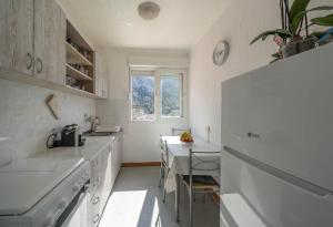 a white kitchen with a sink and a table at The view of Kotor - Sea & Old town view in Kotor