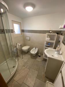 a bathroom with a sink and a toilet and a shower at affittacamere li di Giuan in Lauco +38 photos