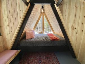 a bed in the middle of a room with a window at Sailor Springs Glamping in Bayfield