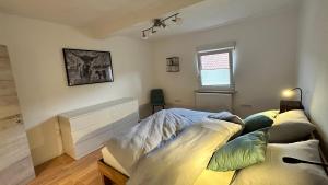 a bedroom with a bed with pillows on it at Heimatliebe Erfweiler Wohnung DREI in Erfweiler