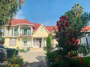 une maison jaune avec un toit rouge dans l'établissement Arundinaria guest house, à Gisenyi