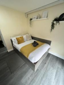 a bedroom with a large bed with white and yellow sheets at west walk house in Nottingham
